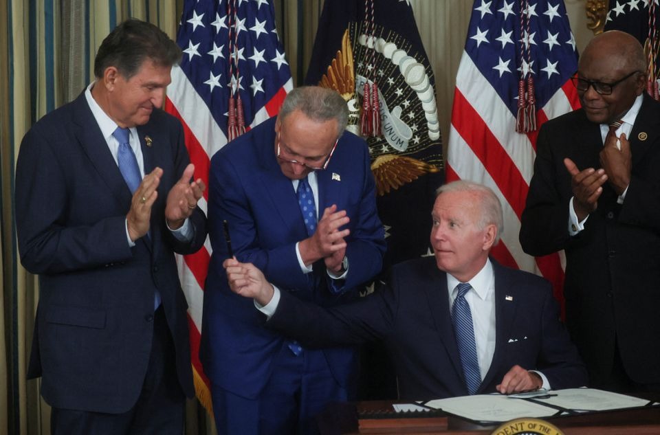 Biden signs inflation act, hands pen to Manchin