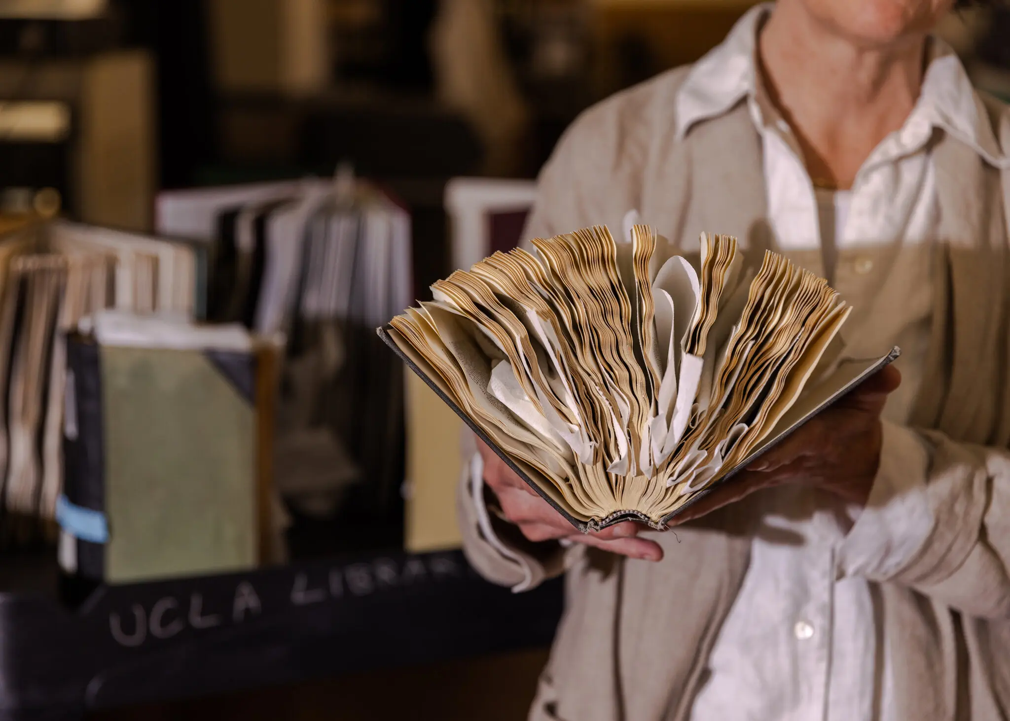 شيلا ميتزجر رئيسة قسم الحفظ في مكتبة جامعة كاليفورنيا مع كتاب تالف بسبب المياه