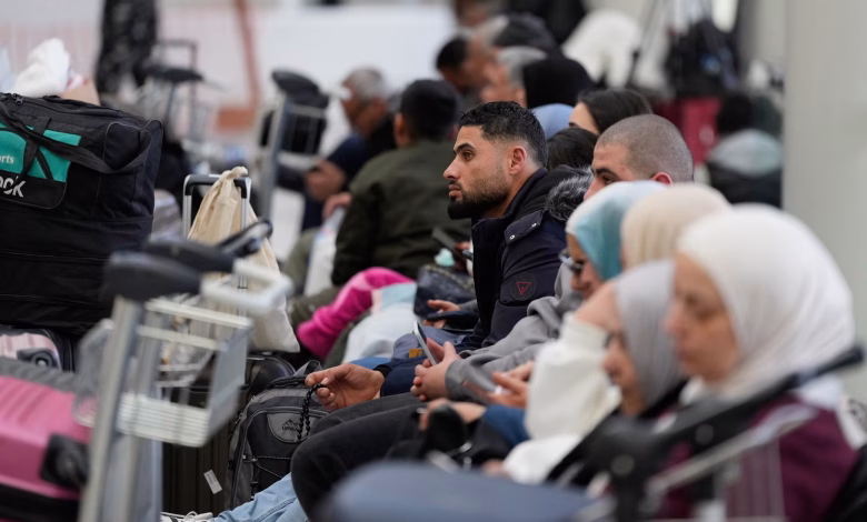 مسافرون ينتظرون أمام لوحات الرحلات الملغاة داخل أحد مطارات الشرق الأوسط ب