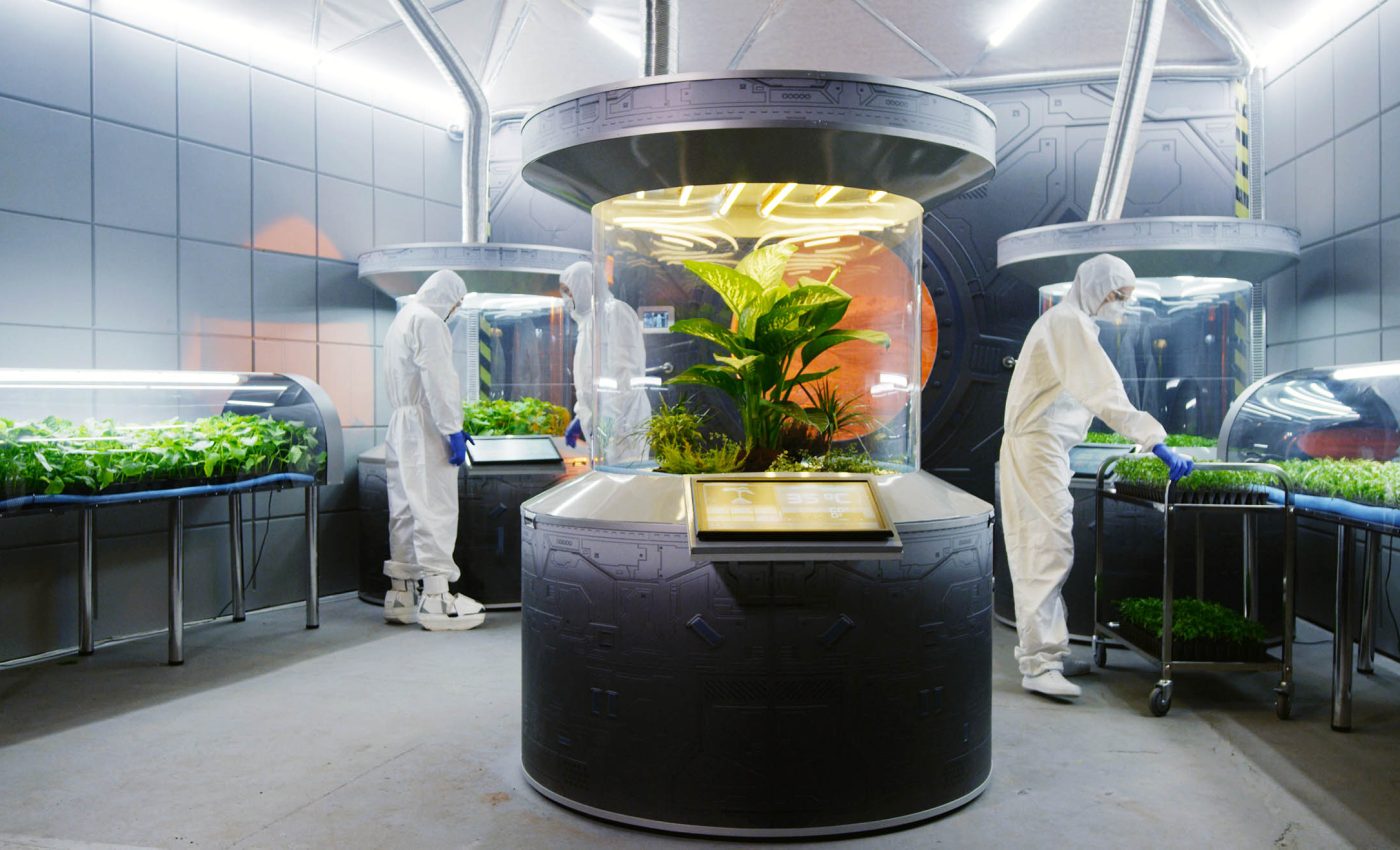 رائد فضاء يعمل داخل بيت زجاجي زراعي على سطح المريخ