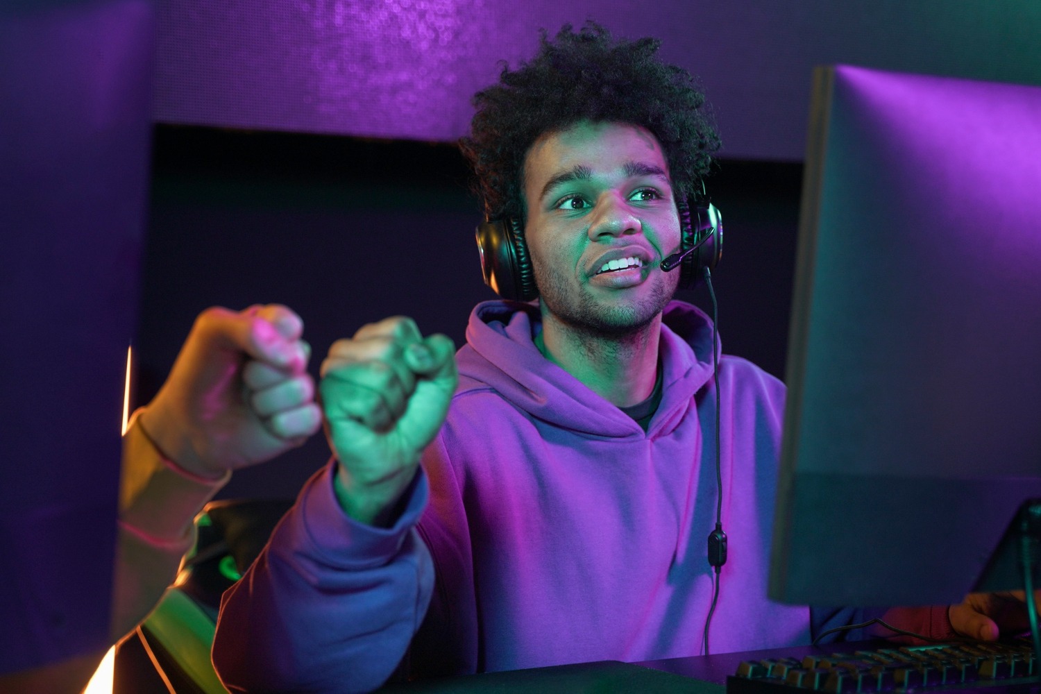 لاعب يرتدي سماعة يحتفل أمام الشاشة